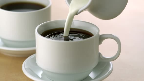 Pouring milk into coffee, Slow Motion alt