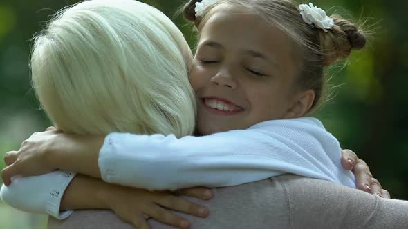 Little Girl Hugging Her Grandmother and Kissing on Cheek, Family Care and Love