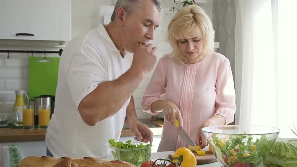 Elderly Family Couple Cooking Salad for Lunch Together in Kitchen