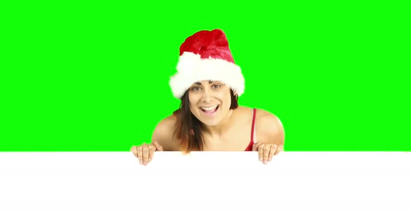 Beauty brunette in santa hat showing white poster 4k