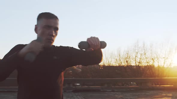 Young and fit man having evening workout outdoor. Urban sunset.