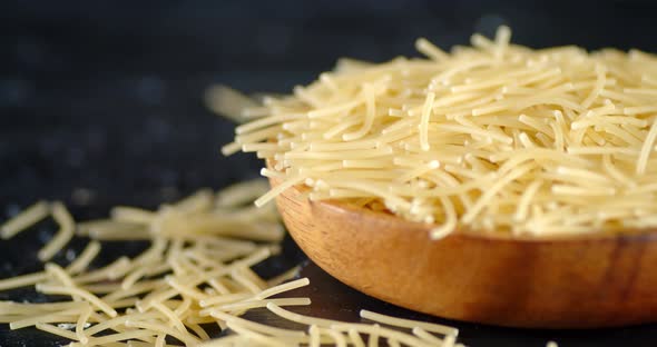 Wooden Plate with Dry Pasta Vermicelli Rotates Slowly. 