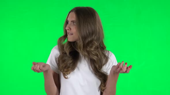 Lovable Girl Is Upset, Waving Her Hands in Indignation, Shrugs. Green Screen