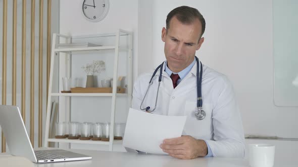 Doctor Reading Documents in Clinic Paperwork