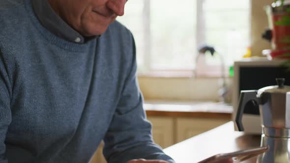 Senior man using digital tablet at home