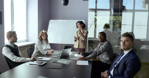 Business Woman Presenting Project To Colleagues Multinational Group Showing Information Screen