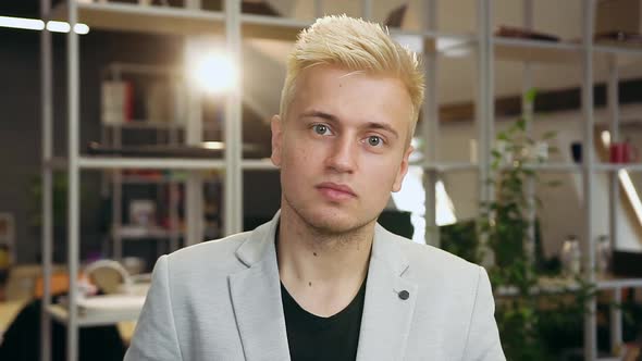 Young Blond Guy Looking at Camera on the Contemporary Office Room