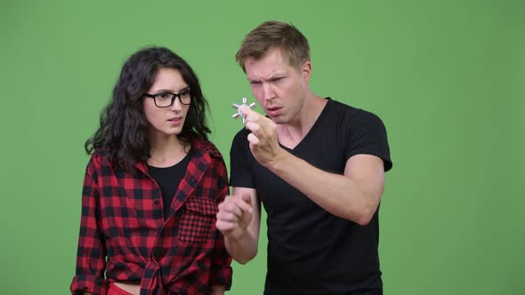 Young Couple Playing with Fidget Spinner Together