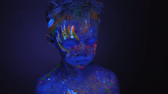 Portrait of a Small Child with a Blue UV Pattern on His Face and Body