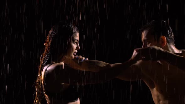 Passionate Young Couple Dancing and Enjoying Pouring Rain at Night