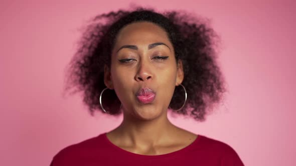 Playful girl in red wear blows bubblegum, chewing gum in slow motion