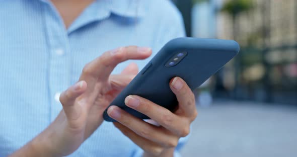 Close up Of Woman Use of Smart Phone in City