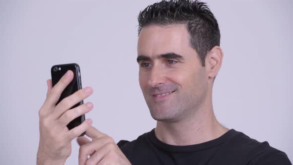 Closeup of Happy Handsome Man Using Phone Against White Background