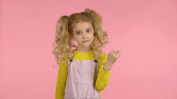 Cute Female Child Is Winding Her Hair on the Finger