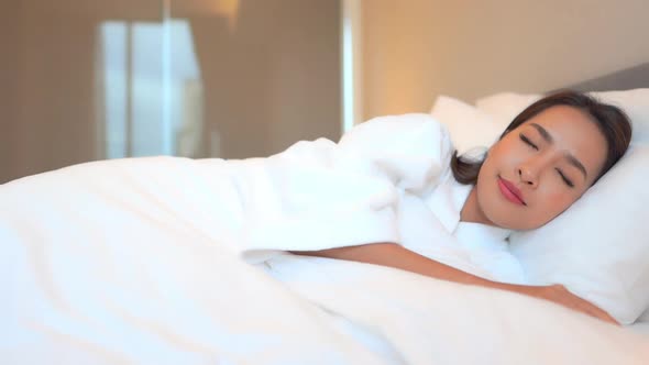 Asian woman relax on bed in bedroom interior