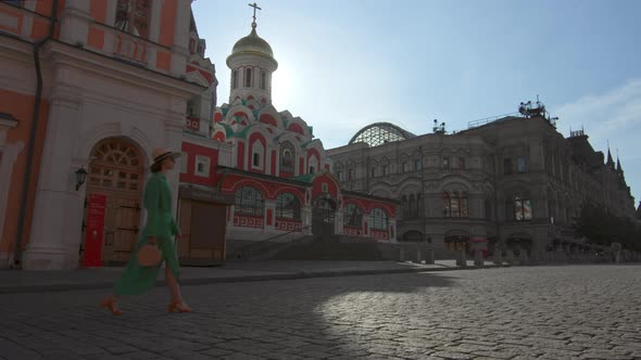 A girl in a green dress walking by the cathedral