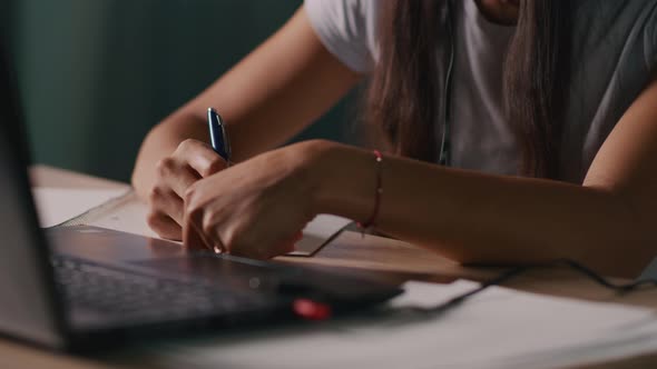 Crop Freelancer Making Notes and Using Laptop