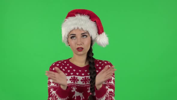 Portrait of Sweety Girl in Santa Claus Hat Is Clapping Her Hands Indifferent. Green Screen