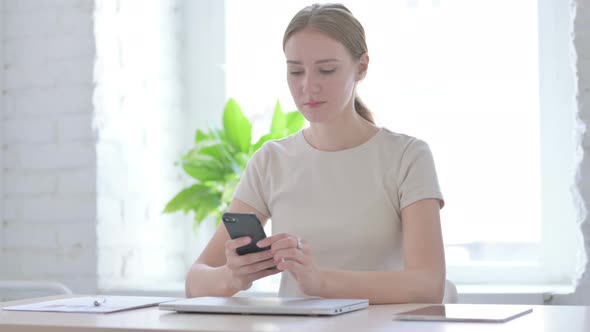 Woman Browsing Internet on Smartphone in Office