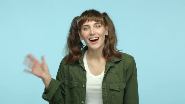 Slow Motion of Cheerful Brunette Woman with Double Ponytail Hairstyle Smiling Friendly and Waving