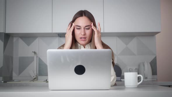 Exhausted Office Worker Pretty Young Girl is Using Laptop Then Touching Head Feeling Tired and