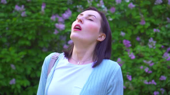 Portrait of a Young Woman Takes Off Her Medical Mask and Breathes Deeply in the Air Against the