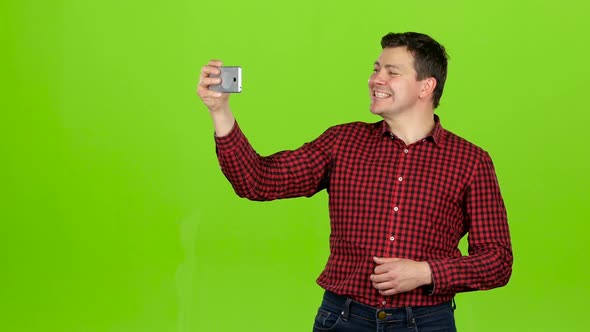 Guy Takes Pictures of Himself, Poses and Smiles. Green Screen