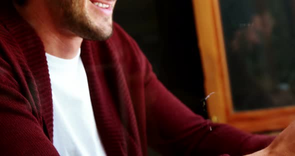 Man using mobile phone while having cup of coffee