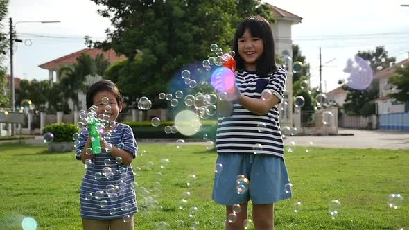 Cute Asian Children Shooting Bubbles From Bubble Gun In The Park Slow Motion