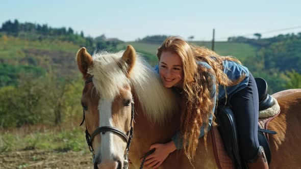 Young woman caressing horse on a ride