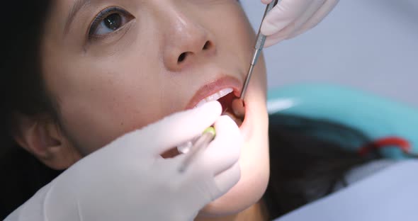 Woman dentist working at her patients teeth