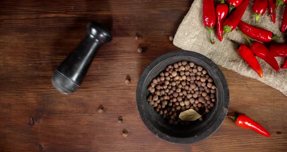 Black Pepper in a Mortar with Red Pepper on the Bag. 