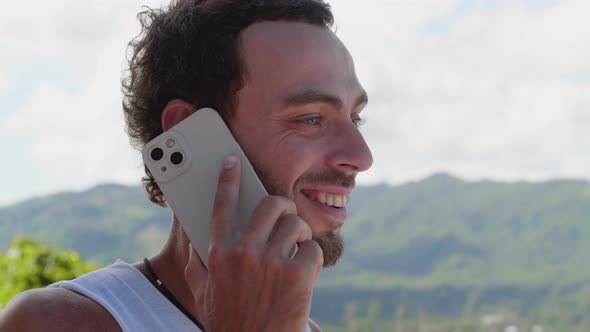 Closeup Portrait of Young Caucasian Handsome Man Talking on Mobile Phone Standing Outdoors