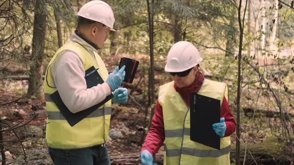 Man and a Woman Ecologists Take Selfies Against Background of Garbage in Forest