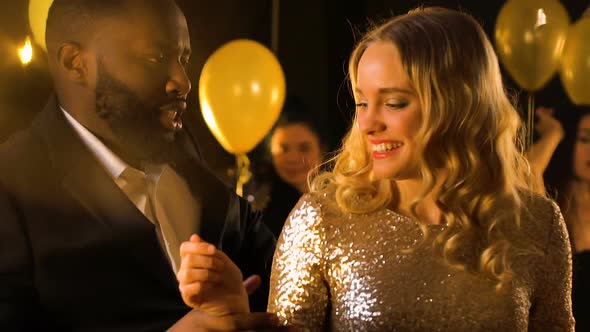 Multiracial Man and Woman Dancing at Party Under Falling Confetti, Celebration