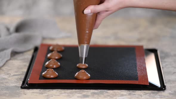 Cooking Chocolate Profiteroles, Female Hands Squeeze the Dough From the Bag Onto Baking Sheet.