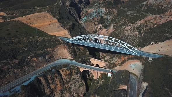 Aerial view of a modern bridge on top of another two older bridges from different periods. Older one