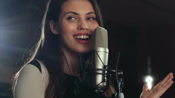 Singer Standing in Front of a Microphone and Singing