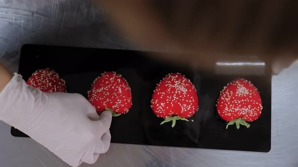 Closeup of a Female Pastry Chef Decorating Mousse Cakes with Red Mirror Glazes