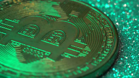 Bitcoin Coins are Illuminated By Multicolored Neon Light in Closeup