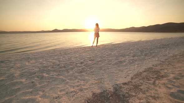 Female Model Walking on the White Sandy Beach of the Clear Tropical Turquoise Sea at Sunset