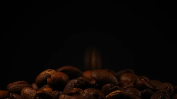 Slow motion of roasted coffee beans falling.