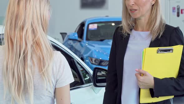 Female Customer Receiving Car Keys, Shaking Hands with Saleswoman