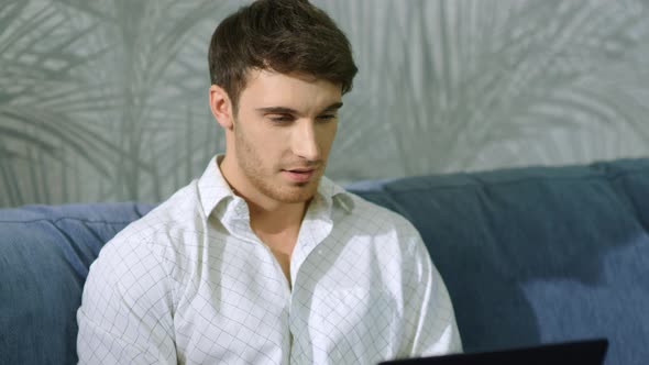 Happy Businessman Messaging Computer Indoors. Cheerful Guy Looking Laptop Screen