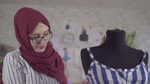 Young Muslim Woman Fashion Designer in National Headscarf Makes a Fitting on a Blue Dress on a