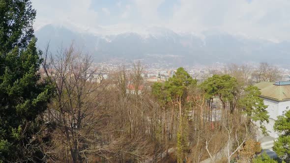 Beautiful Aerial View of Big City at Bottom of Austrian Alps, Snow on Mountains