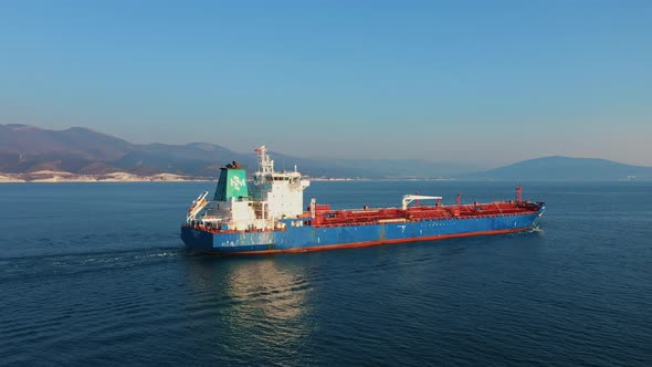 Aerial View of Large Cargo Ship Leaving Sea Harbour at Sunny Day