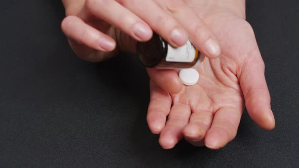 Two Big White Round Pills Fall Into Palm of Hand From Pill Bottle