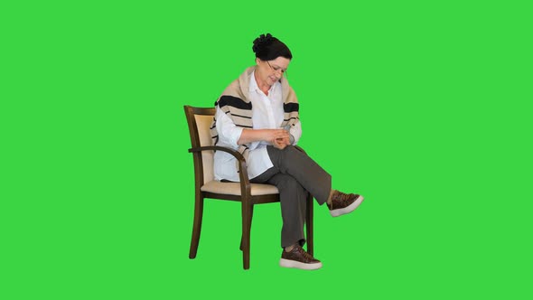 Mature Woman Using Blood Pressure Measurement Device and Feeling Good on a Green Screen Chroma Key