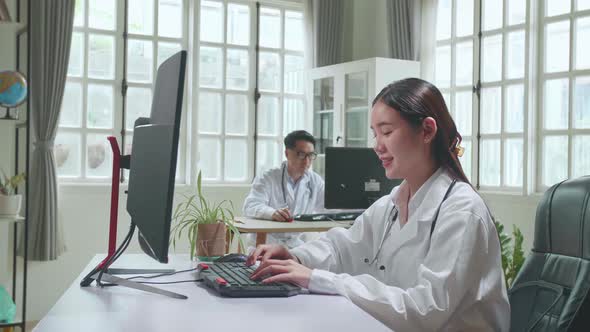 Young Asian Woman Doctor Is Using Computer In Workplace. Medical Concept